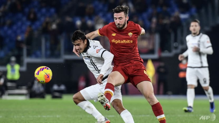 Roma's Italian midfielder Bryan Christante (R) holds back Spezia's Slovakian forward David Strelec during the Italian Serie A football match between AS Roma and Spezia on December 13, 2021 at the Olympic stadium in Rome. (Photo by Filippo MONTEFORTE / AFP)