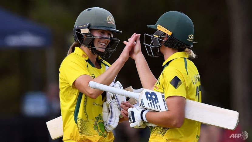 Australia's Ellyse Perry (left) and captain Meg Lanning celebrate as Australia defeat England in a women's one-day international cricket match in Melbourne on Feb 8, 2022.
